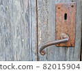 old rusted door handle on a wooden door 82015904