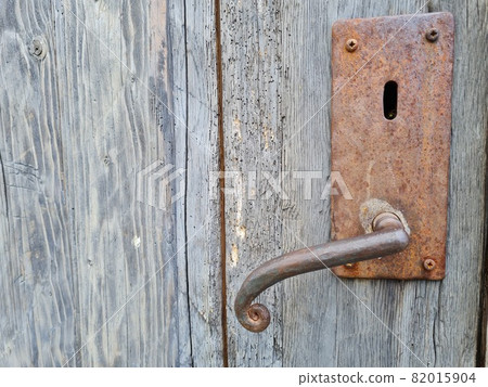 old rusted door handle on a wooden door old rusted door handle on a wooden door 82015904