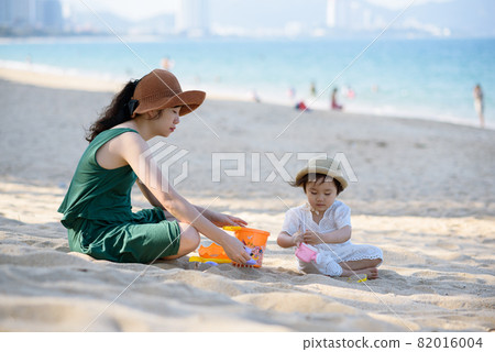Mother and daughter picnic at the beach 82016004
