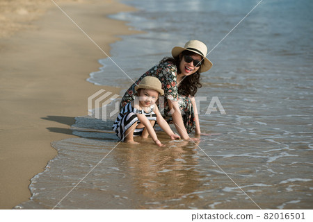 Mother and daughter having fun on the beach Mother and daughter having fun on the beach 82016501