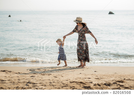 Mother and daughter having fun on the beach 82016508