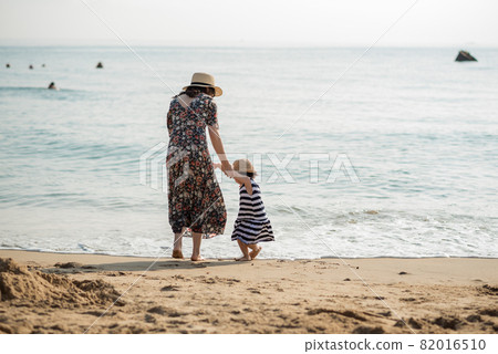 Mother and daughter having fun on the beach Mother and daughter having fun on the beach 82016510