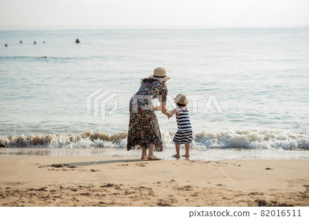 Mother and daughter having fun on the beach Mother and daughter having fun on the beach 82016511