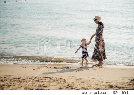 Mother and daughter having fun on the beach Mother and daughter having fun on the beach 82016513
