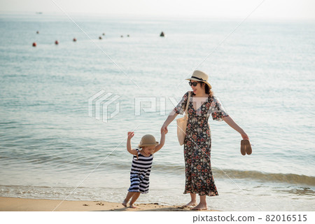Mother and daughter having fun on the beach Mother and daughter having fun on the beach 82016515
