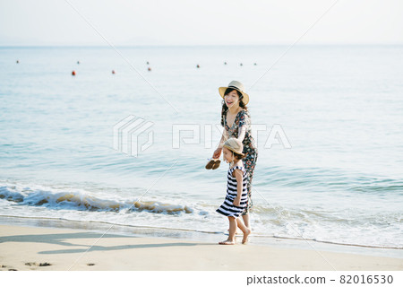 Mother and daughter having fun on the beach Mother and daughter having fun on the beach 82016530