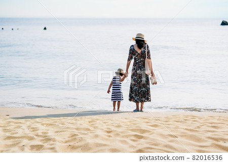 Mother and daughter having fun on the beach 82016536