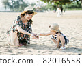 Mother and daughter having fun on the beach 82016558