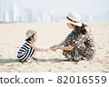 Mother and daughter having fun on the beach 82016559