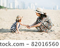 Mother and daughter having fun on the beach 82016560