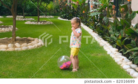 cute little girl, 3 years old, with two ponytails on her head, wearing a multi-colored T-shirt and cute little girl, 3 years old, with two ponytails on her head, wearing a multi-colored T-shirt and 82016699