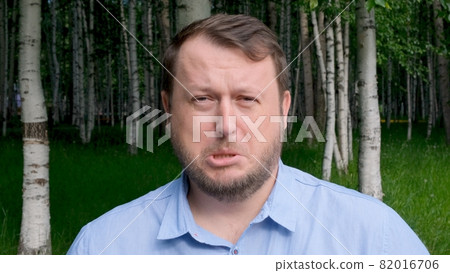 face of a distressed and sad man, 35 years old, dressed in a blue shirt on the street with emotions face of a distressed and sad man, 35 years old, dressed in a blue shirt on the street with emotions 82016706