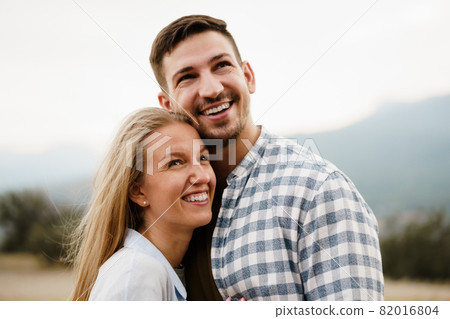 Happy loving couple hiking and hugging in mountains 82016804