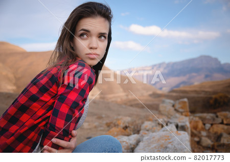 Portrait of attractive caucasian young woman enjoying in the mountains against the background of epic rocks looking away 82017773