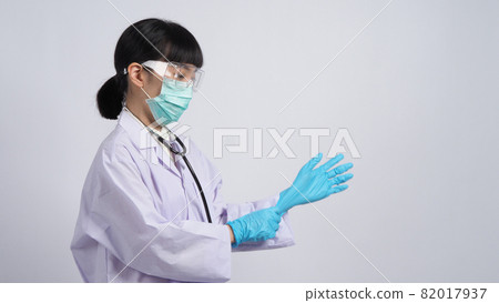 Wearing gloves. Asian doctor wear blue rubber nitrile hands glove. Doc with a mask putting on gloves. isolated white background copy space. Health care protection coronovirus pandemic concept. 82017937