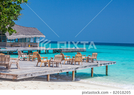 Hotel terrace on the beach of a Maldives island with bungalow in typical design 82018205