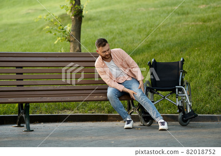 Disabled man transfers from wheelchair to a bench Disabled man transfers from wheelchair to a bench 82018752
