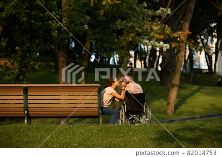Love couple, care for disabled man in wheelchair Love couple, care for disabled man in wheelchair 82018753