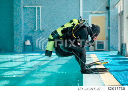 Male divers in scuba gear jump into the pool Male divers in scuba gear jump into the pool 82018786