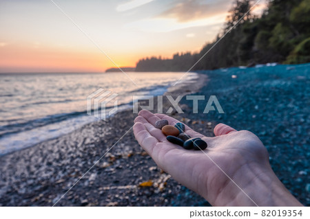 Female Hand holding rocks and pebble at Sandcut Beach on the West Coast 82019354