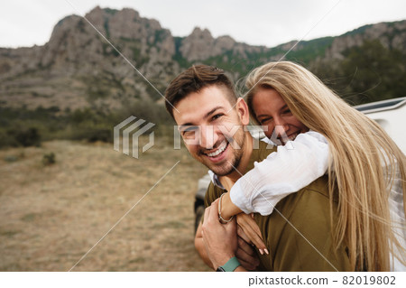 Happy loving couple hiking and hugging in mountains 82019802