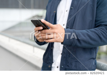 Close up Man texting on cell phone. 82020421