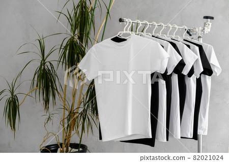 Row of black and white t-shirts hanging on rack Row of black and white t-shirts hanging on rack 82021024