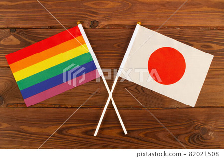 Rainbow flag LGBT and flag of Japan on brown wood planks background. LGBT Pride Month. LGBTQ. LGBTQIA. Close Up. Top view 82021508