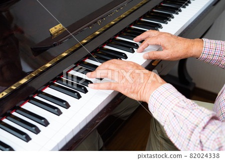 Hands of a senior man playing the piano 82024338