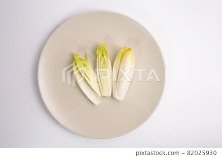 endive on plate top view on white background, salad chicory roots, healthy organic food concept endive on plate top view on white background, salad chicory roots, healthy organic food concept 82025930