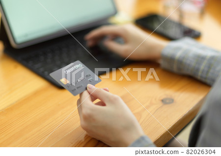 Close up woman hand using credit card and tablet 82026304