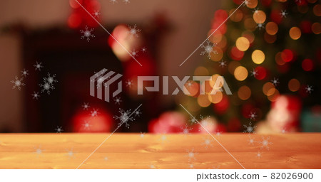 Snowflakes falling against flickering fairy lights on Christmas tree Snowflakes falling against flickering fairy lights on Christmas tree 82026900
