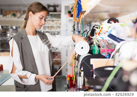 Seamstress looking for ribbons in haberdasher shop Seamstress looking for ribbons in haberdasher shop 82026929