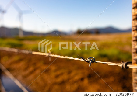 Closeup of fance in countryside landscape with cloudless sky 82026977