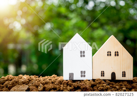 Miniature houses on soil with copyspace. Building blocks arranged in row. Miniature houses on soil with copyspace. Building blocks arranged in row. 82027125
