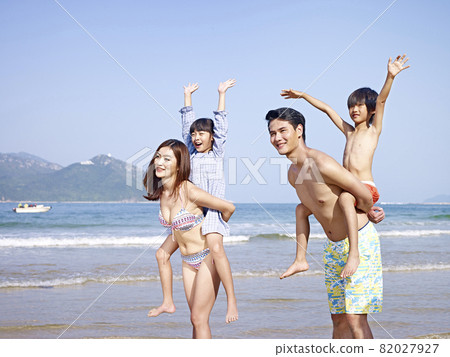 asian family with two children having fun on beach 82027927