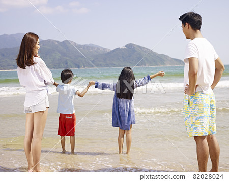 asian family with two children having fun on beach asian family with two children having fun on beach 82028024