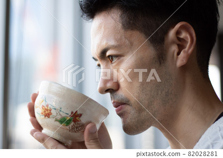 A middle-aged man drinking matcha in an autumn-patterned bowl at a coffee shop in Kyoto's main store 82028281
