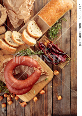 Smoked sausage with bread and spices on a old wooden table. 82029457