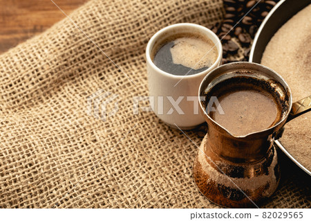White coffee cup with roasted beans on sackcloth 82029565