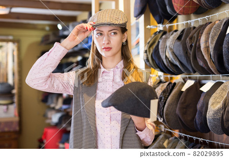 Woman trying on hat during shopping Woman trying on hat during shopping 82029895