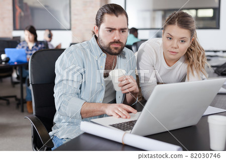 Woman explaining project to male coworker Woman explaining project to male coworker 82030746