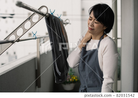 Image of a housewife who feels stiff shoulders and tiredness 82031542
