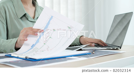 Hand of businesswoman are planning business investments related to shares By analyzing and calculating the stock market for marketing profits Hand of businesswoman are planning business investments related to shares By analyzing and calculating the stock market for marketing profits 82032314