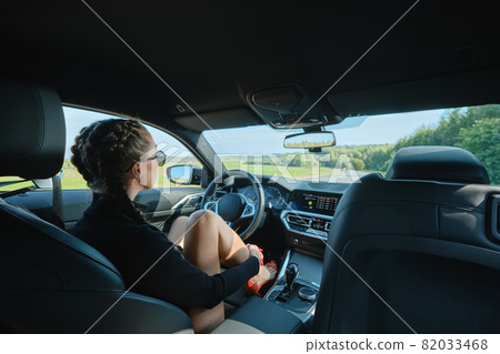 Pretty woman sitting behind the steering wheel 82033468