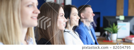 Group of people are sitting on armchair with documents in hands and listening to lecture 82034795