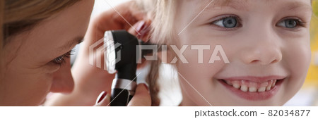 Ent doctor examining sore ear of small child using otoscope Ent doctor examining sore ear of small child using otoscope 82034877
