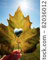 Leaf with the Alps view through the heart shape cut 82036012