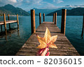 Hand holding a yellow autumn leaf at the pier 82036015