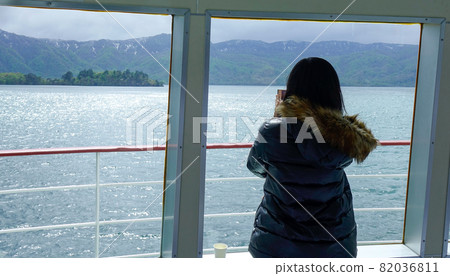 Woman seeing the lake scenery from ferry Woman seeing the lake scenery from ferry 82036811